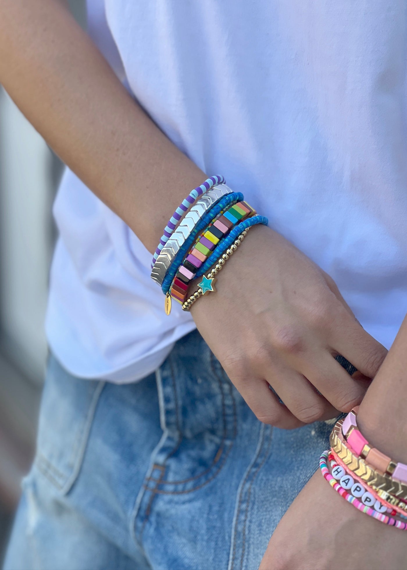 Hammill & Co Mixed blue  set of 8 bracelets on elastic. Features multicoloured beaded bracelet, multi cube enamel bracelets and gold bracelet with aqua star.