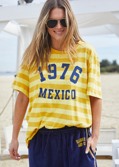 Hammill & Co Slouchy crew neck tee in a soft yellow and mustard stripe jersey with navy retro Mexico print on the front. Looks great worn back with the velour pants and shorts!