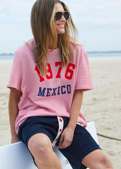 Hammill & Co tee is a total throwback in the best way. With fine red and white stripes and a pop of red and navy “1976 MEXICO” across the front.