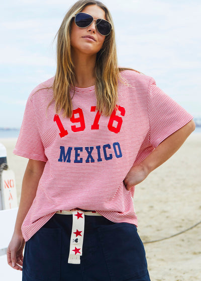 Hammill & Co tee is a total throwback in the best way. With fine red and white stripes and a pop of red and navy “1976 MEXICO” across the front.