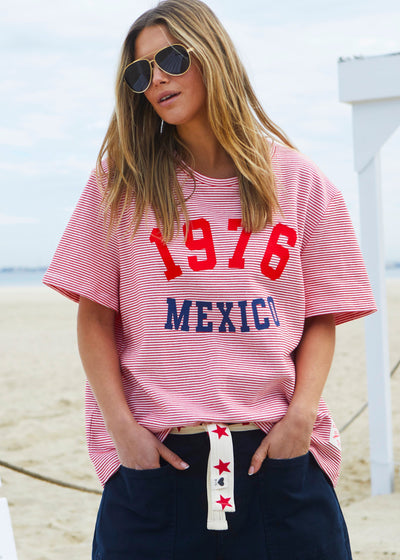 Hammill & Co tee is a total throwback in the best way. With fine red and white stripes and a pop of red and navy “1976 MEXICO” across the front.