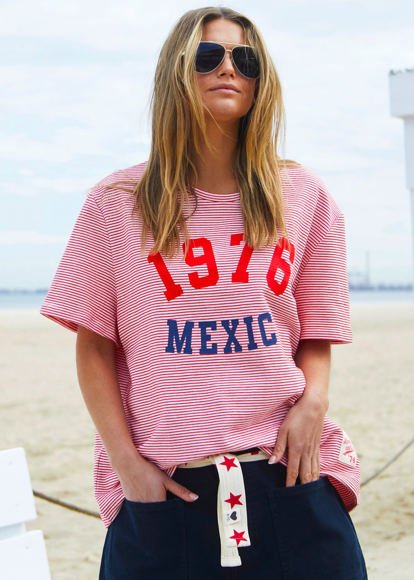 Hammill & Co tee is a total throwback in the best way. With fine red and white stripes and a pop of red and navy “1976 MEXICO” across the front.