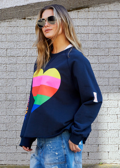 Hammill & Co Dark navy with multi coloured heart print on the front and multi coloured FOLLOW YOUR DREAMS down the right sleeve.