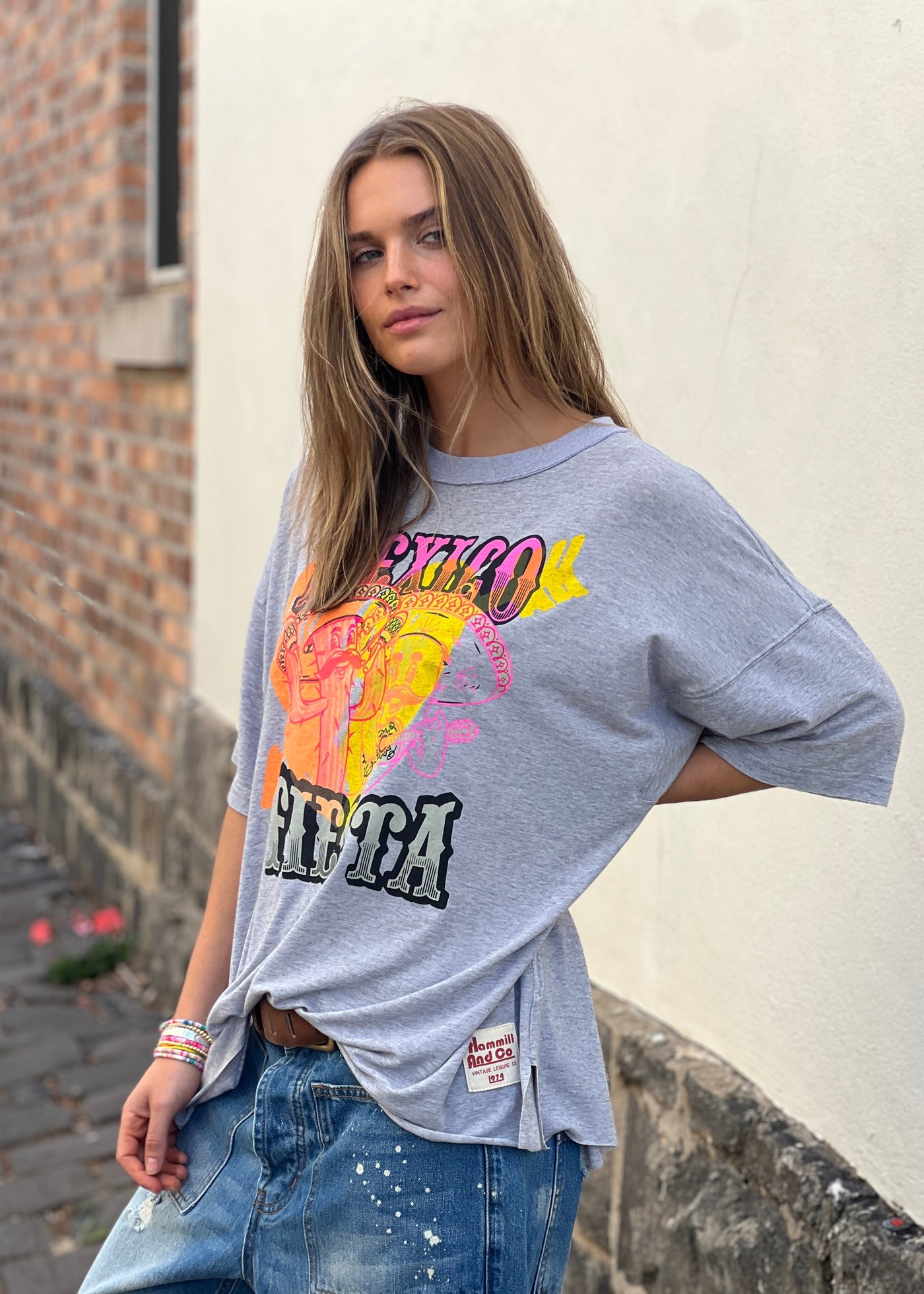 Hammill & Co oversized fit tee in a washed light grey marle colour with multi coloured print o the front. Slouchy wider fit, drop longer sleeve and cut raw hem.