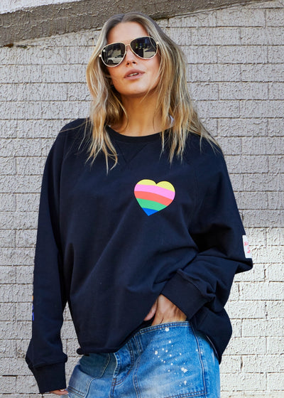 Hammill & Co Black sweat with small multi coloured heart print on the left chest and multi coloured FOLLOW YOUR DREAMS down the right sleeve