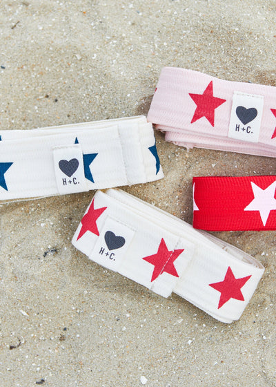 Hammill & Co Stretch natural tape with red stars printed on one side and the other side plain. The end has small H+C badge.
