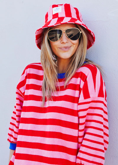 Hammill & Co bold striped bucket hat is pure summer happiness. Made from soft terry towelling in vibrant red and pink stripes