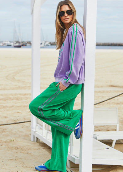 Hammill & Co New wider leg track pant in our luxurious, lightweight velour with velour stripes down each leg, draw cord and Hammill and Co logo print on left hem. The fit is a true to size, not oversized.