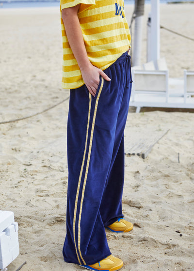 Hammill & Co New wider leg track pant in our luxurious, lightweight velour with velour stripes down each leg, draw cord and Hammill and Co logo print on left hem. The fit is a true to size, not oversized.
