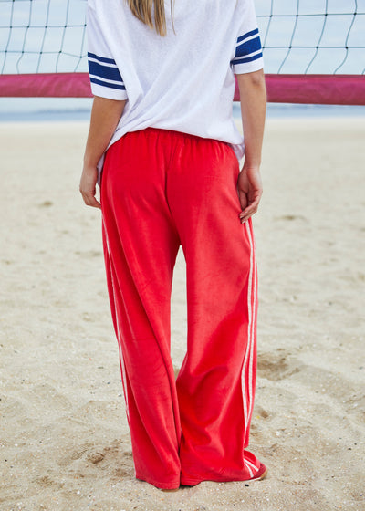 Hammill & Co New wider leg track pant in our luxurious, lightweight velour with velour stripes down each leg, draw cord and Hammill and Co logo print on left hem. The fit is a true to size, not oversized.